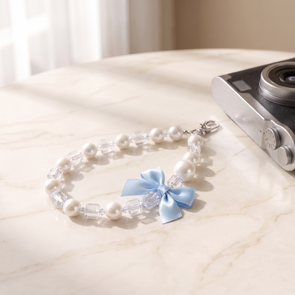 Blue Bow pearl bead wrist strap with a baby blue satin bow charm on cream marble