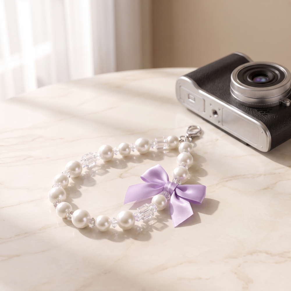 Lilac Bow pearl bead wrist strap with a lilac satin bow charm on cream marble