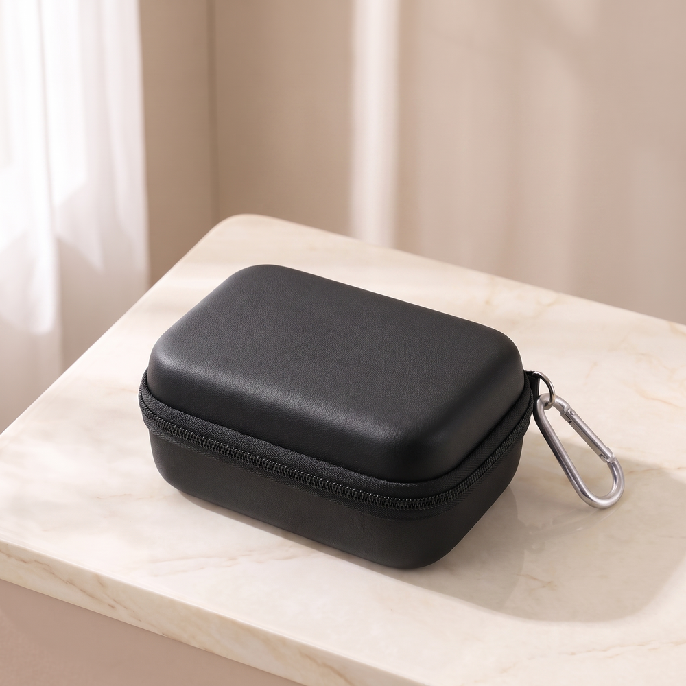 Black hard shell camera case, closed, on cream marble with its carabiner clip