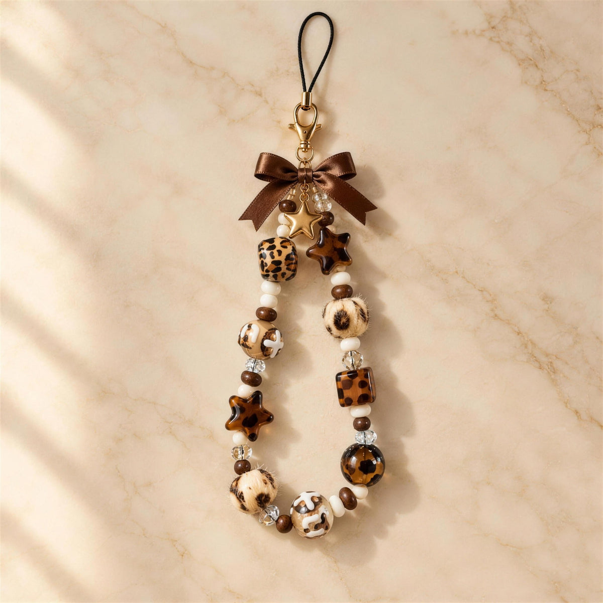 Leopard Star beaded phone charm on marble